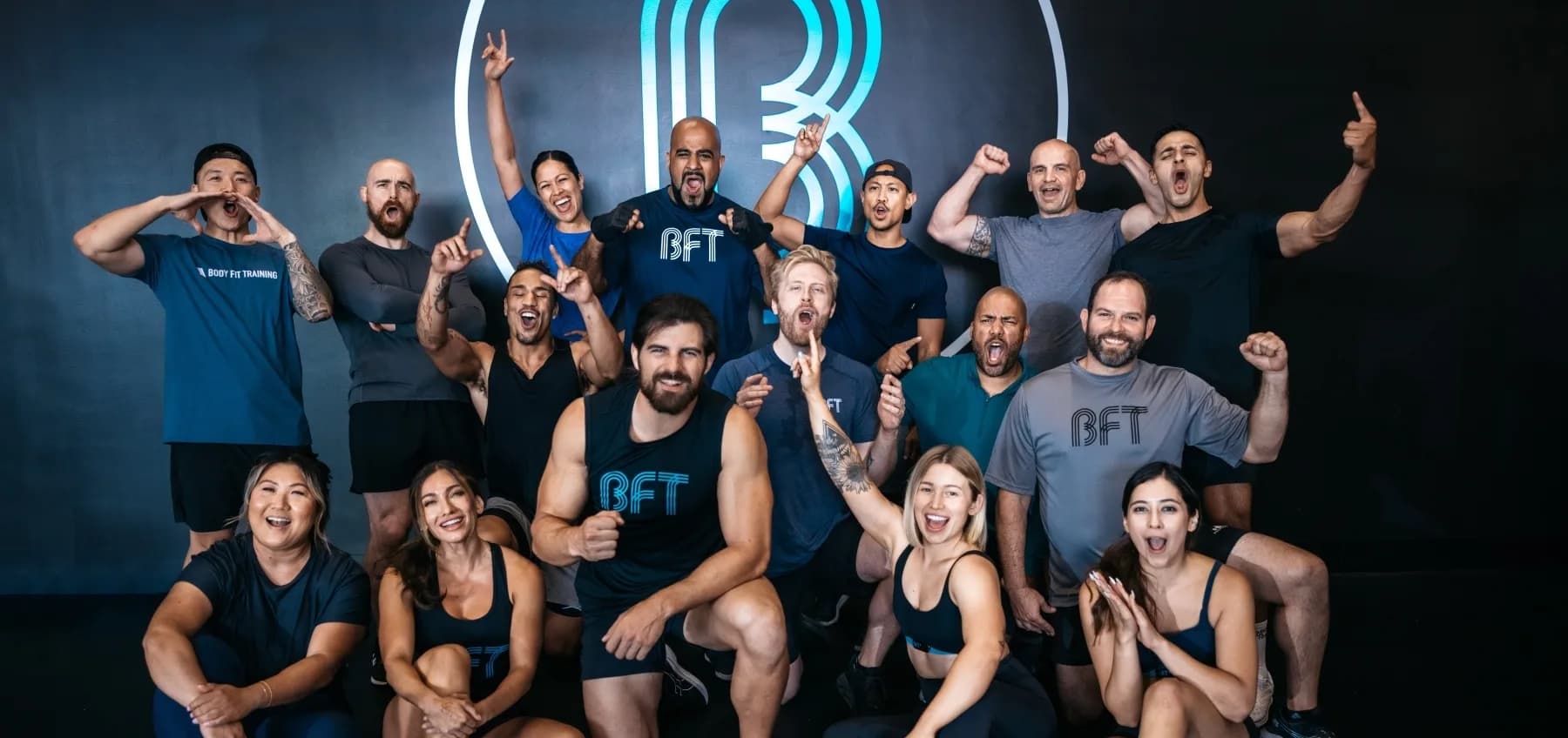 BFT Body Fit Training members and coaches celebrating together inside a studio
