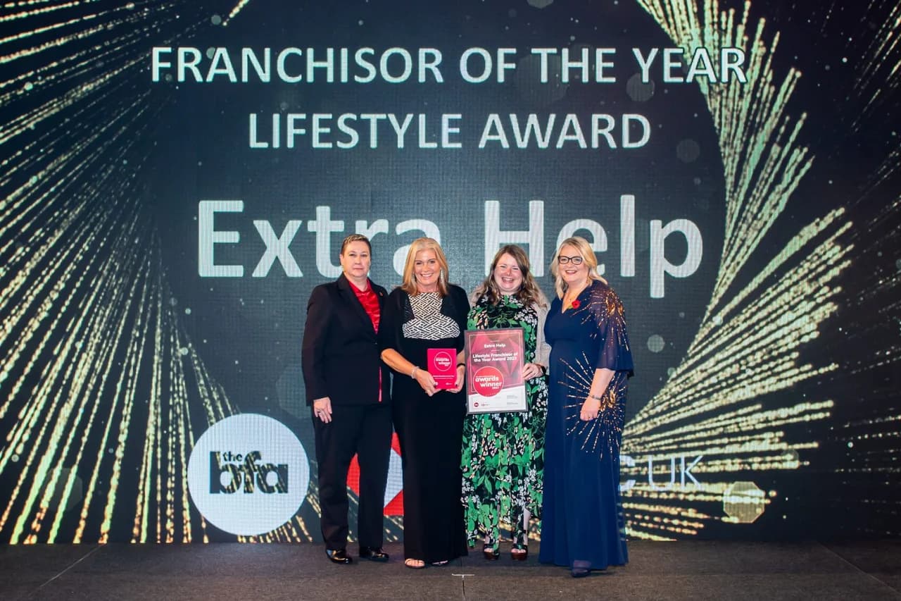 Extra Help founder Claire Robinson and her team on stage at the British Franchise Association awards, holding the 'Franchisor of the Year Lifestyle Award' plaque as Extra Help is announced the winner