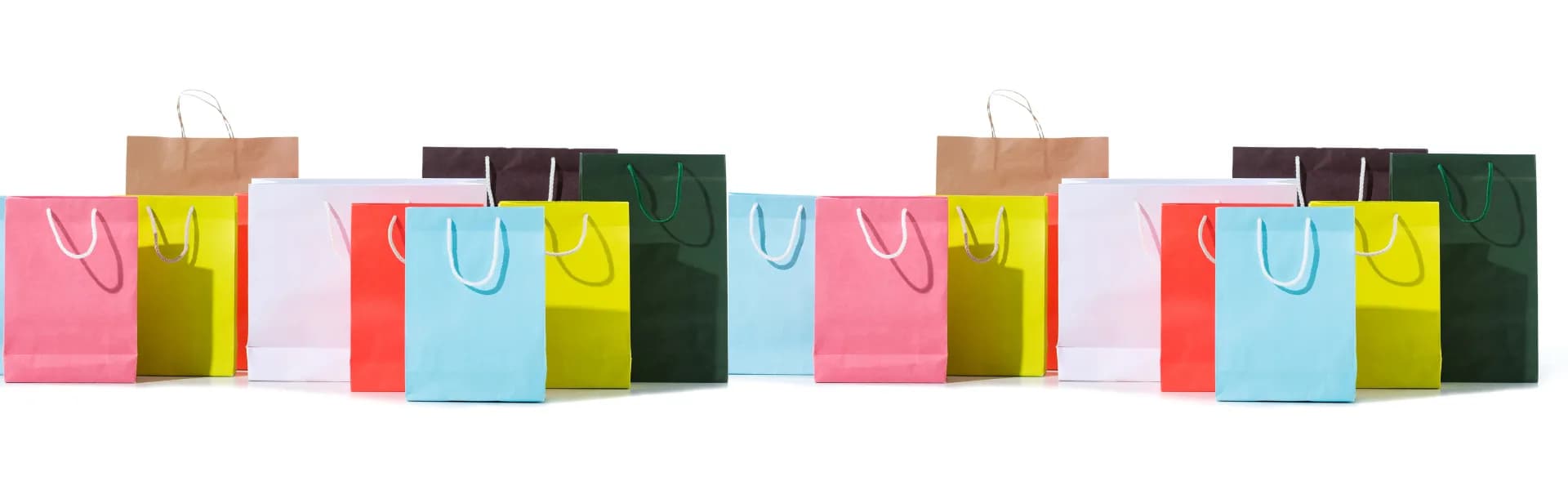 Row of colourful paper shopping bags arranged on a white background, representing merchandising franchise opportunities in the UK.