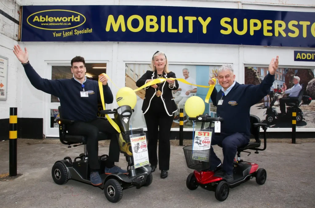 Ableworld Franchise mobility superstore ribbon-cutting with staff and scooters