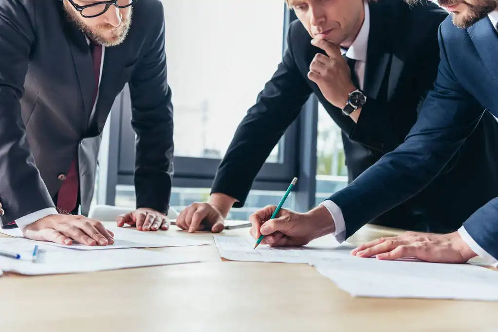 Affinity Associates Franchise business professionals reviewing financial documents at office table